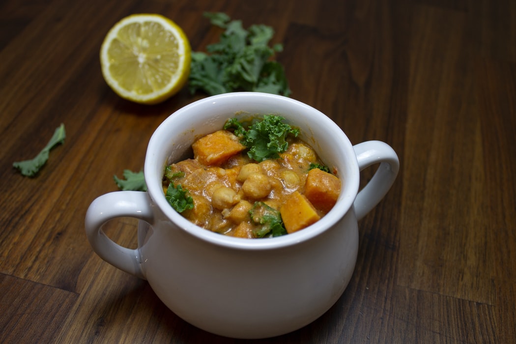 kichererbsensuppe indisch in einem kleinen weißen topf mit zitrone und petersilie