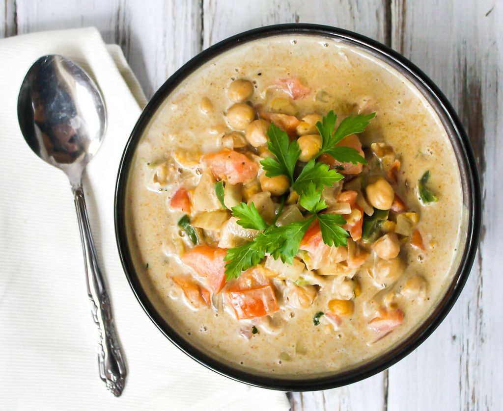 kichererbsensuppe indisch mit tomaten und petersilie auf einem weißen tisch