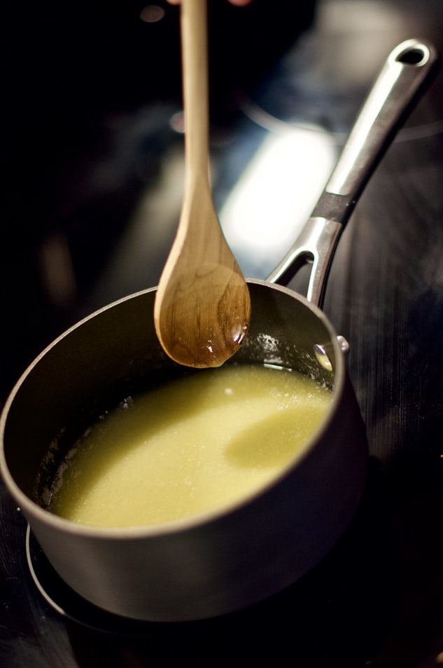 kichererbsensuppe mit kokosmilch kochen und umrühren im einem schwarzen topf auf dem herd