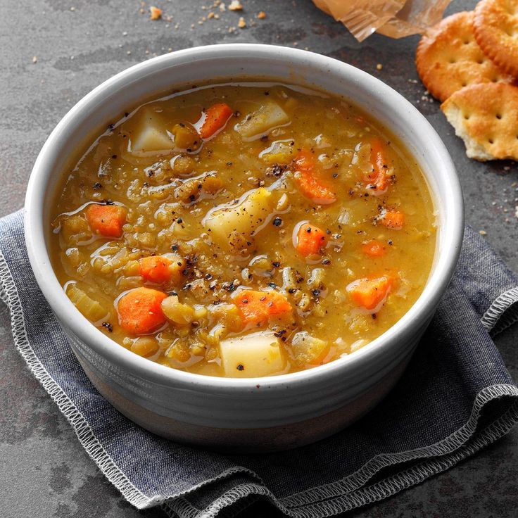 kichererbsensuppe mit möhren und crackers im großen topf auf dem steintisch