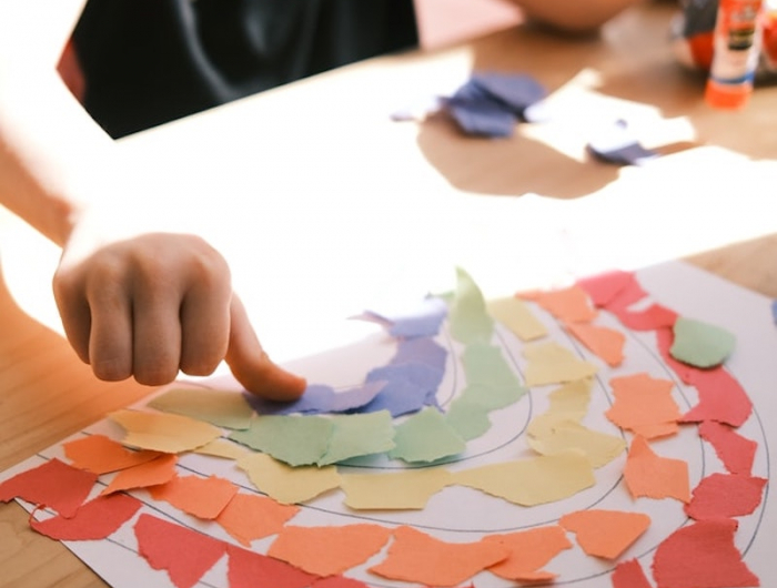 basteltipps für kinder ein mädchen klebt regenbogen aus papier
