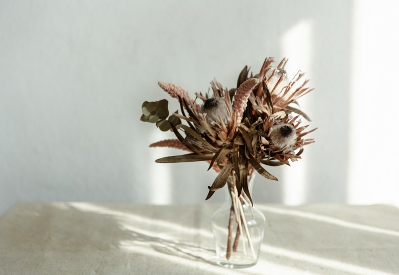 arrangement of dried flowers in a glass vase close up.