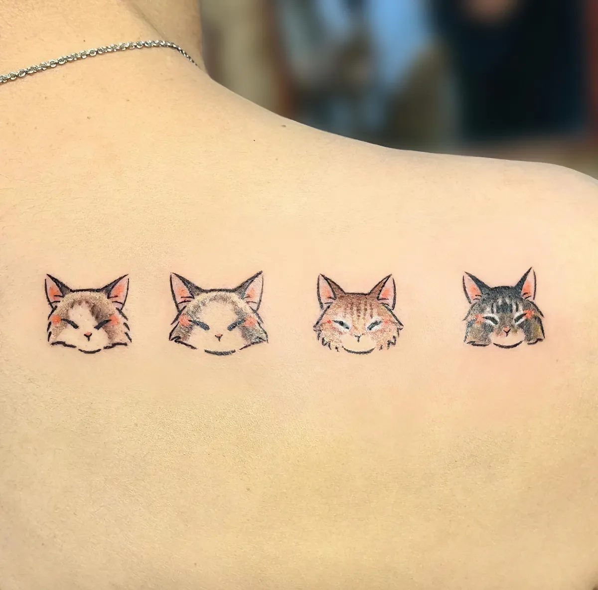 farbiges tattoo am rücken katzenfamilie vier katzen