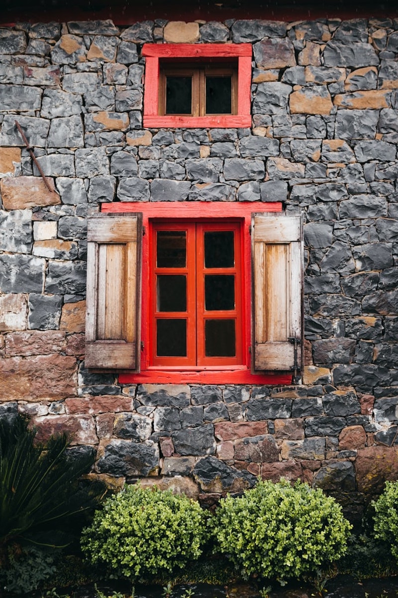 fassade mit spülmittel reinigen steinhaus mit roten fenstern