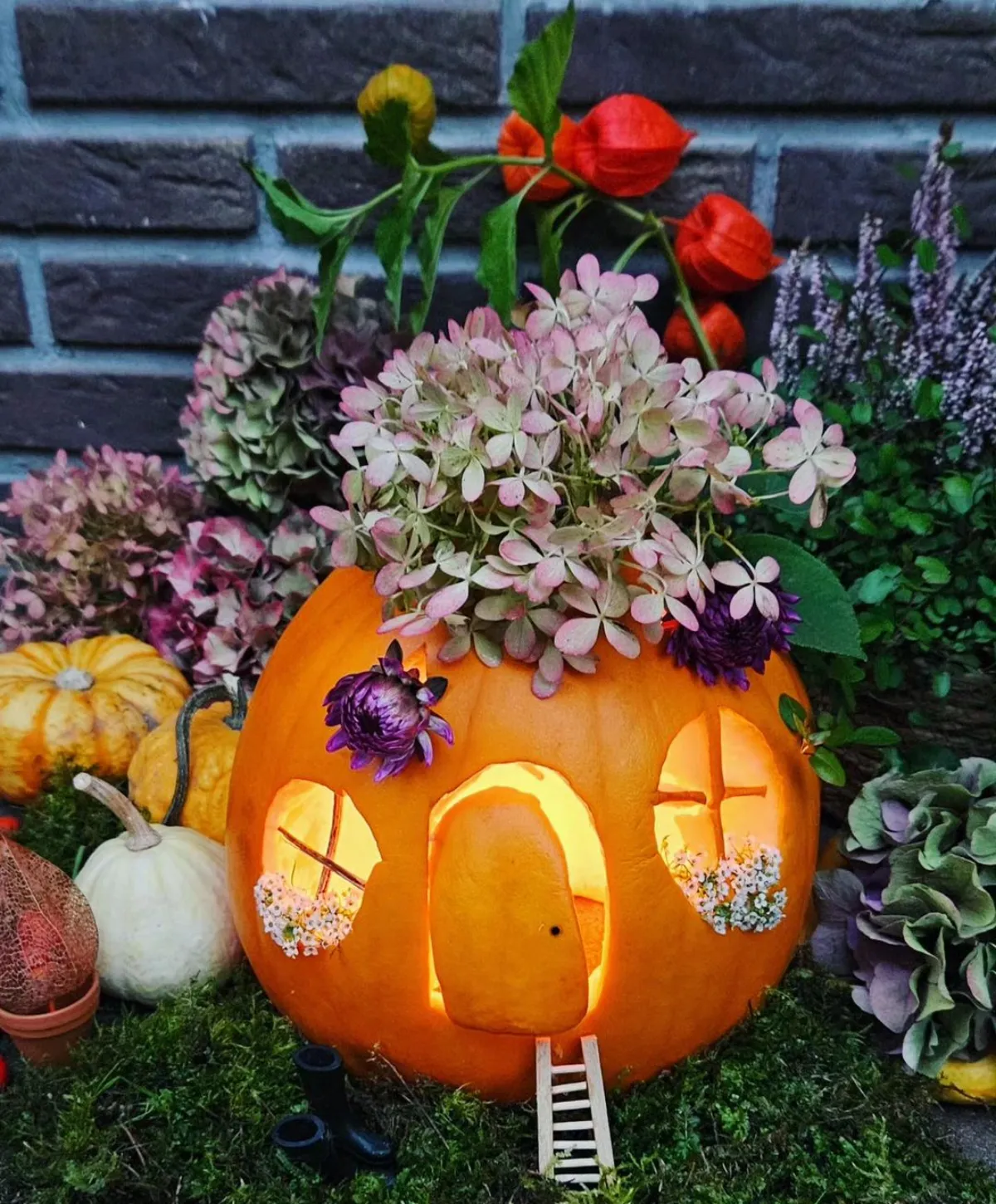 halloween kürbis als haus mit fenstern mit blumen dekoriert