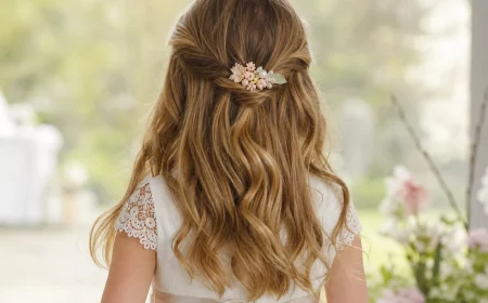Kommunionfrisuren für Mädchen: halboffene Locken mit Blütenschmuck von hinten