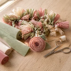 Krepppapierrollen, Fransengirlande und Rose beim Basteln mit Krepppapier
