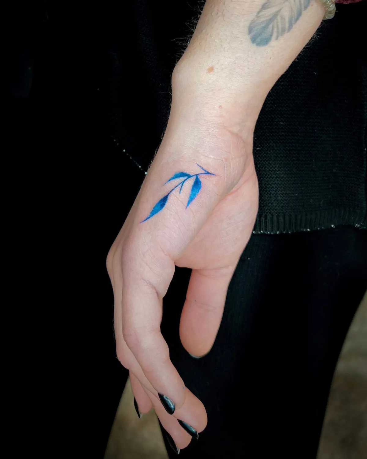 blaues kleines hand tattoo mit ranken in wasserfarben optik