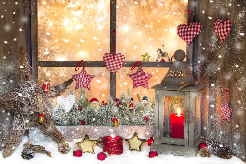 red christmas decoration with lantern on window sill with wood