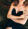 close up hands of elegant beautiful woman sitting in vintage cafe in black velvet dress holding little golden purse in hand, rich stylish lady, elegant fashion trendy accessories