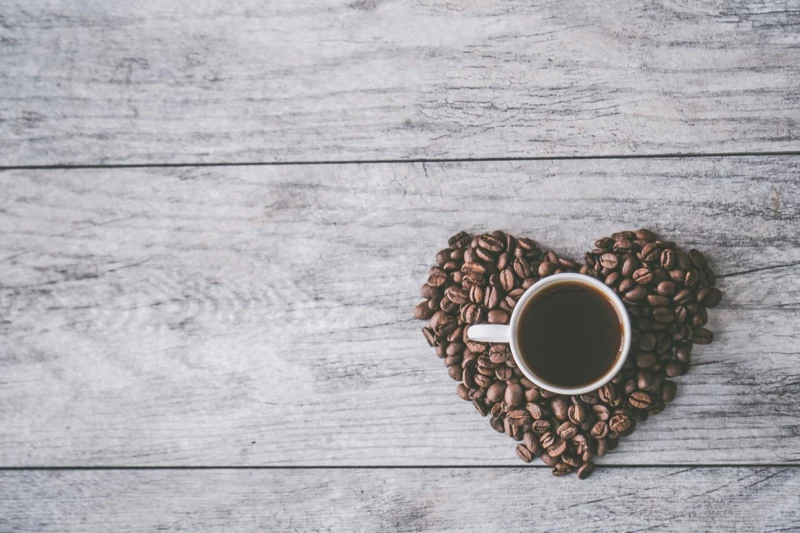 herz aus kaffeebohnen weiße tasse mit kaffee