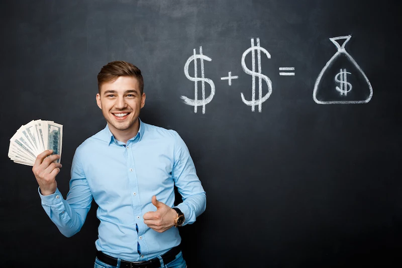 handsome man standing over blackboard with drawn dollar concept