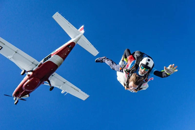 was schenkt man jemandem der schon alles hat fallschirm springen mann und frau springen von flugzeug