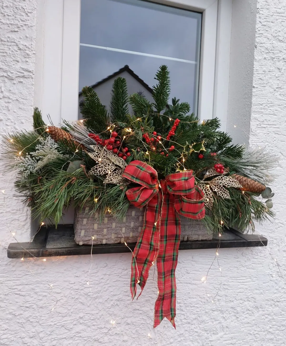 weihnachtsdeko ideen 2024 fensterbank als akzent echte tannenzweige rote karierte schleife