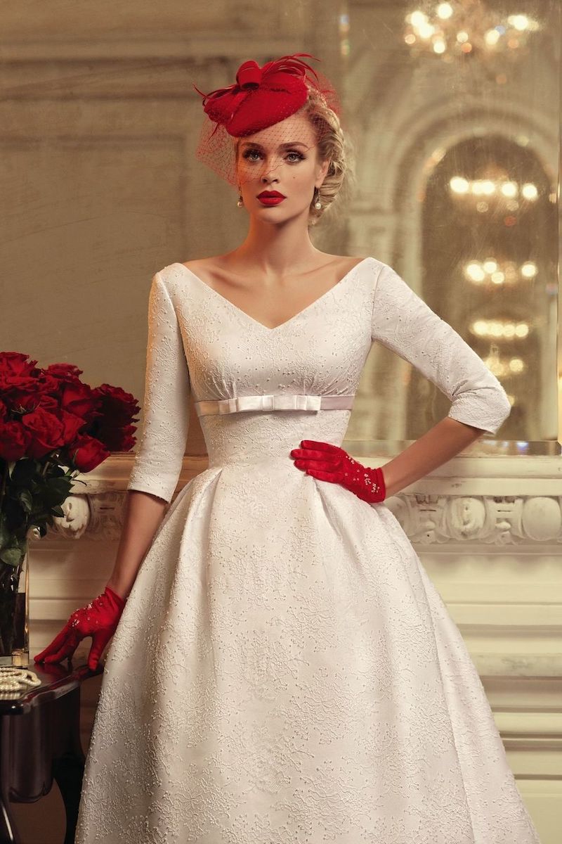brautkleid winter elegante dame in weißer 50er stil kleid mit rote handschuhe und käppchen