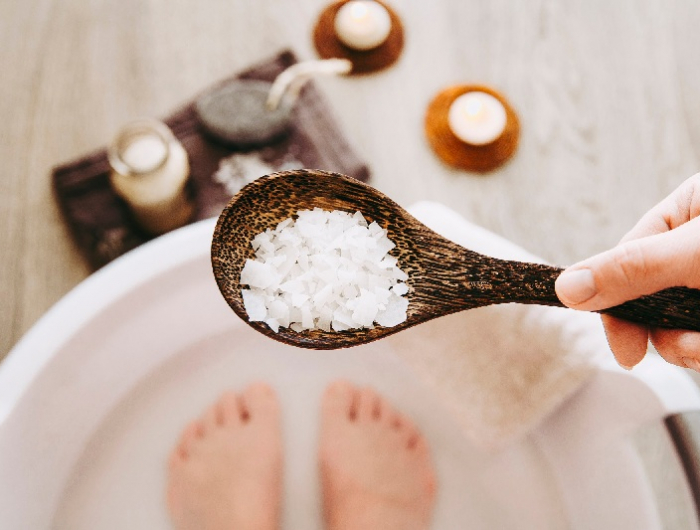adding magnesium chloride vitamin salt in foot bath water, solution. magnesium grains in foot bath water are ideal for replenishing the body with this essential mineral, promoting overall wellbeing.