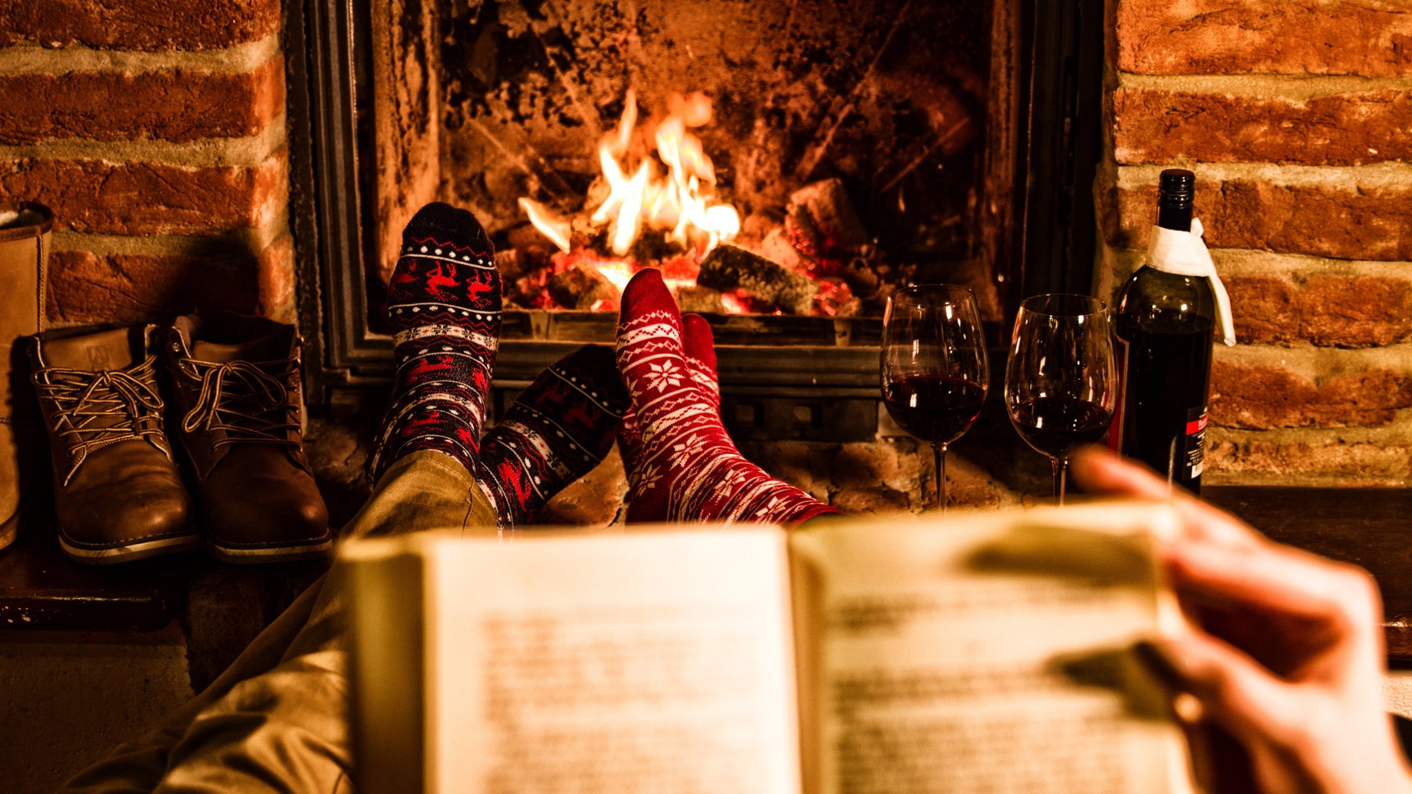 couple with book resting by fireplace during xmas