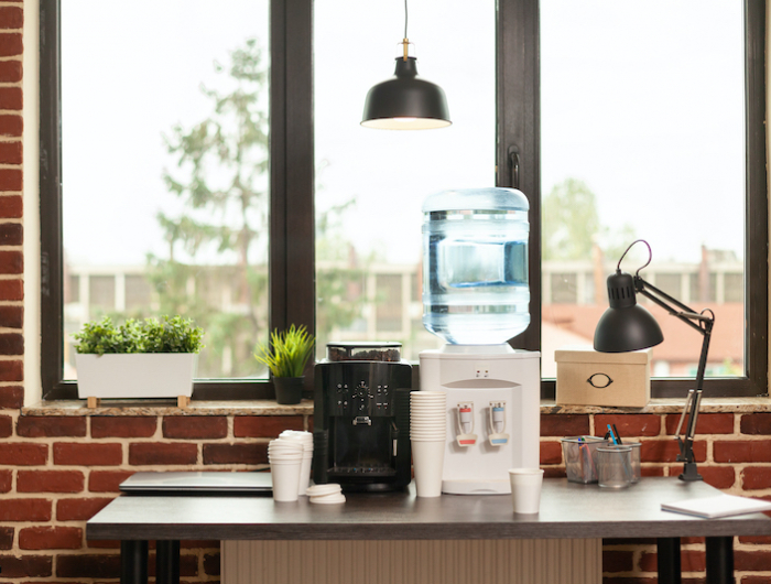 close up of water dispenser and coffee machine on table in meeting office
