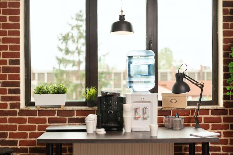 close up of water dispenser and coffee machine on table in meeting office