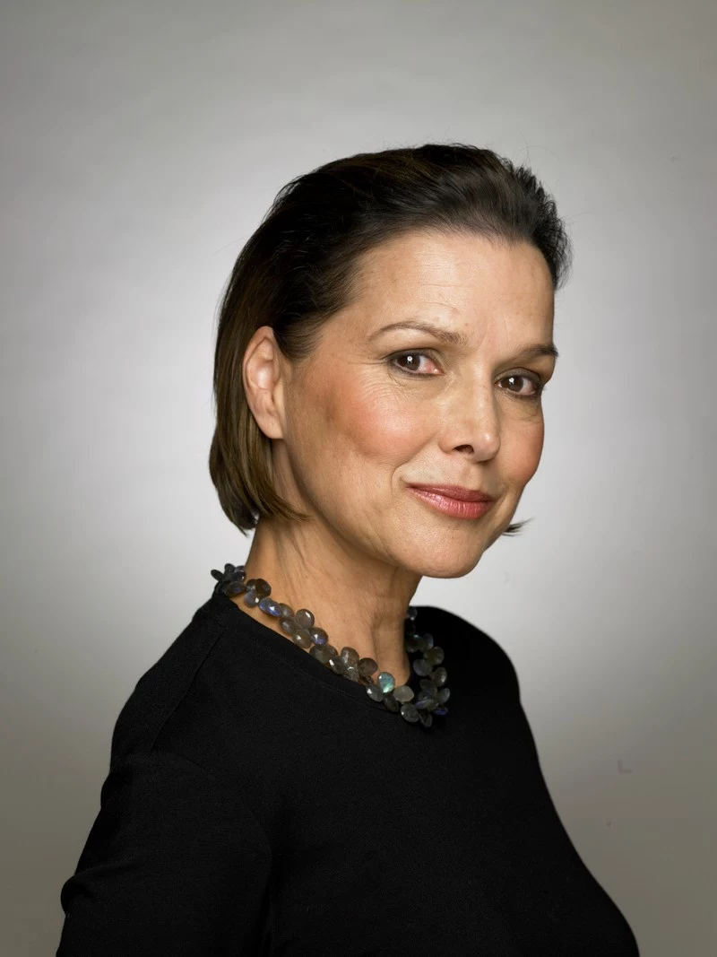 mature woman wearing black top and necklace, portrait