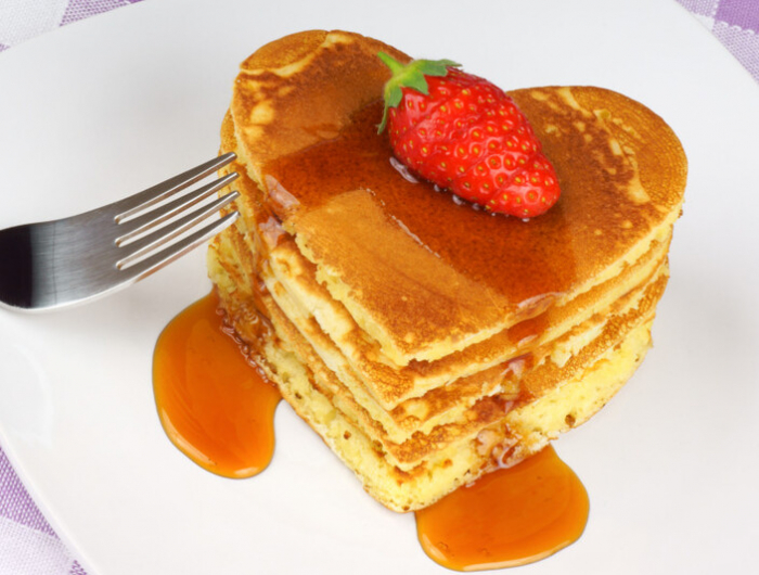 heart shaped pancakes with syrup and strawberry