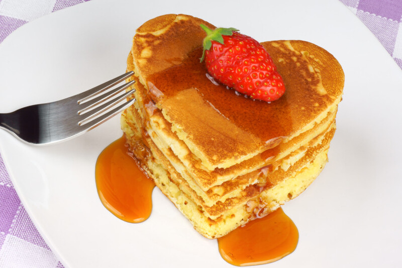 heart shaped pancakes with syrup and strawberry