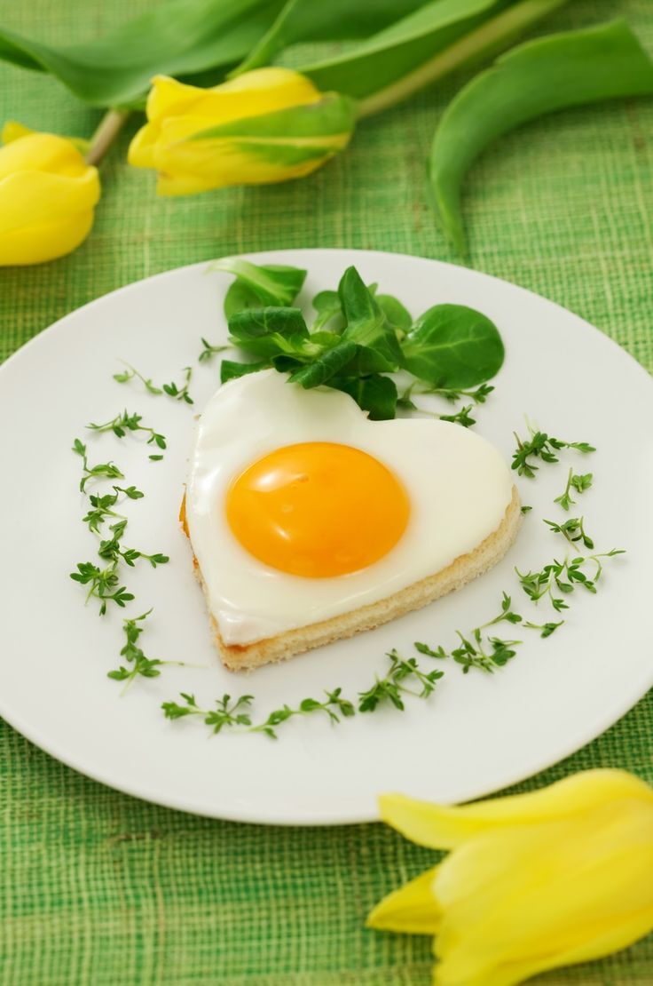 fried egg on heart shaped toast with cress and corn salad for valentine's day