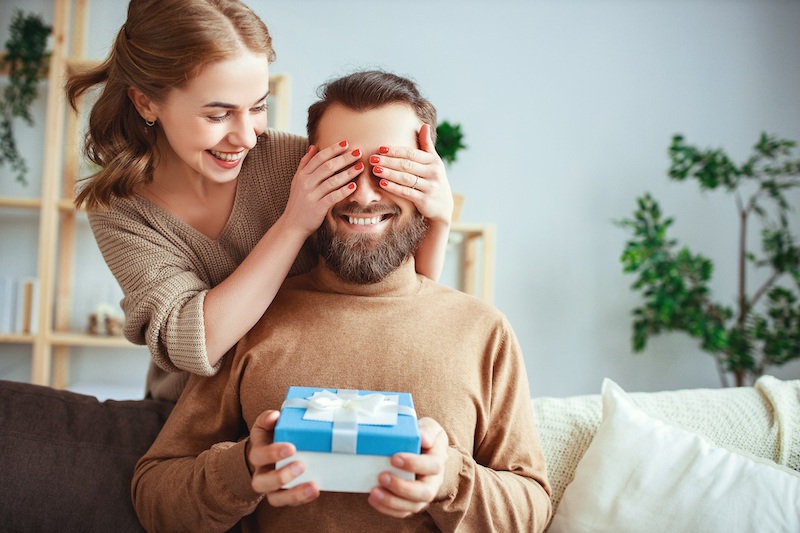 happy married couple man and woman give a gift for holiday