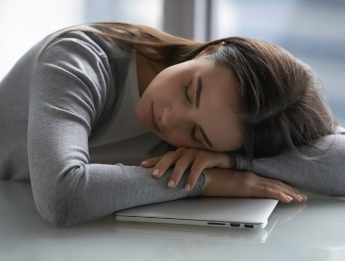 fruehjahrsmuedigkeit symptome schlaffstoerungen chronisch muede frau schlaeft auf ihrem laptop ein