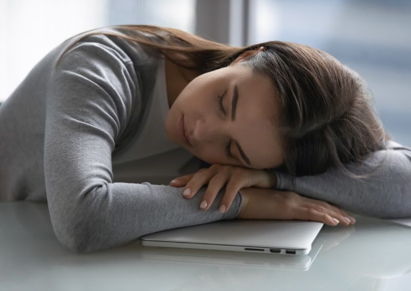 fruehjahrsmuedigkeit symptome schlaffstoerungen chronisch muede frau schlaeft auf ihrem laptop ein