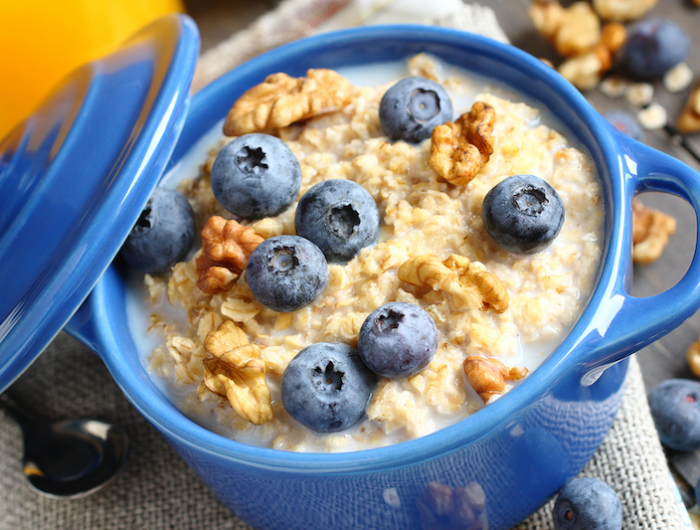 oatmeal with fresh blueberries over a rustic wooden background