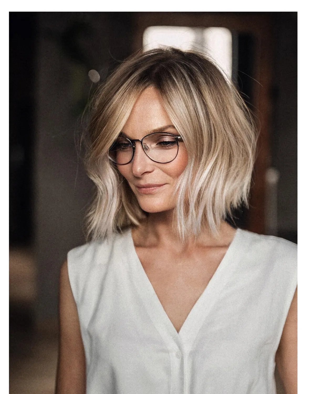 shoene frau ueber 5o mit choppy long bob und seitenscheitel mit brille