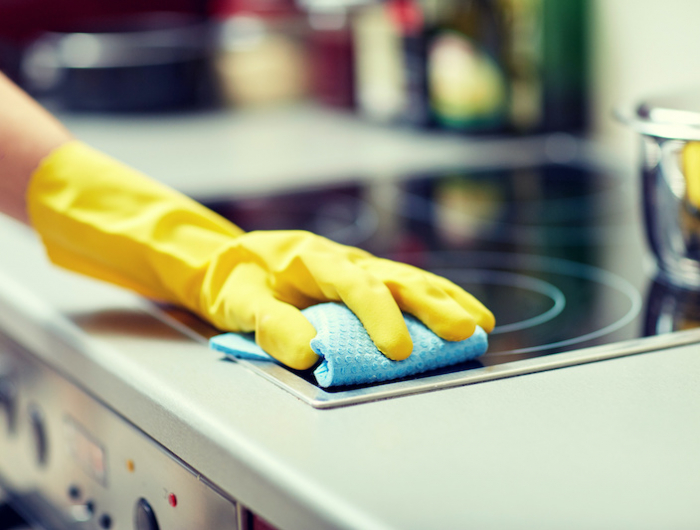 close up of woman cleaning cooker at home kitchen