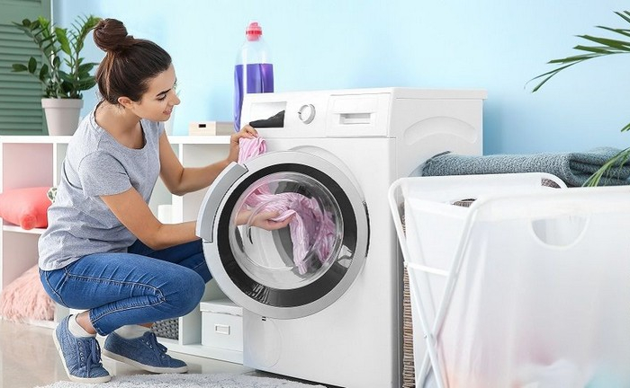 bettwanzen vorbeugen zuhause bettwanzen im hotel was tun frau fuellt die waschmaschine