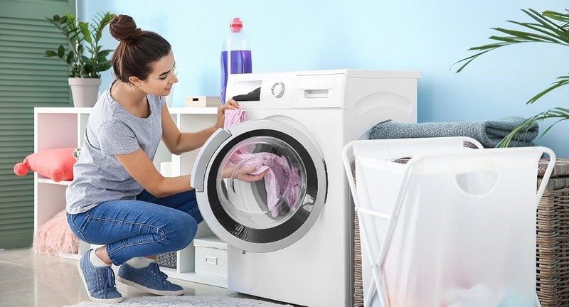 bettwanzen vorbeugen zuhause bettwanzen im hotel was tun frau fuellt die waschmaschine