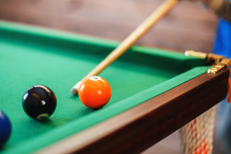balls on a billiard table in a triangle. men playing billiards
