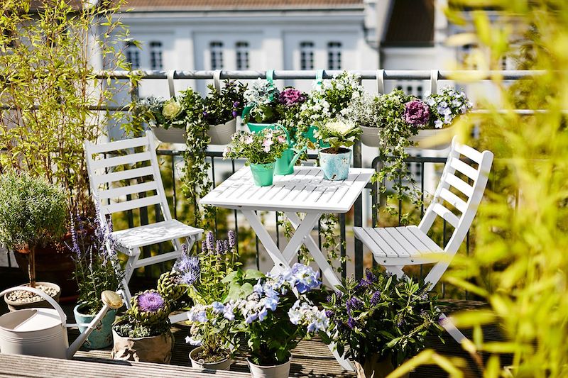 kleinen balkon guenstig gestalten klapptischstuhl klappbarer tisch weiss gruene pflanzen als sichtschutzjpeg