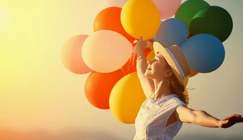 tag des positiven denkens eine schoene frau mit ballonen