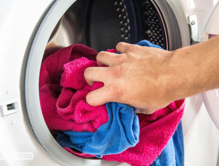 warum werden handtuecher hart wenn sie an der luft trocknen waschmaschine mit handtuechern beladen blaue und rosa handtuch in die waschmaschine