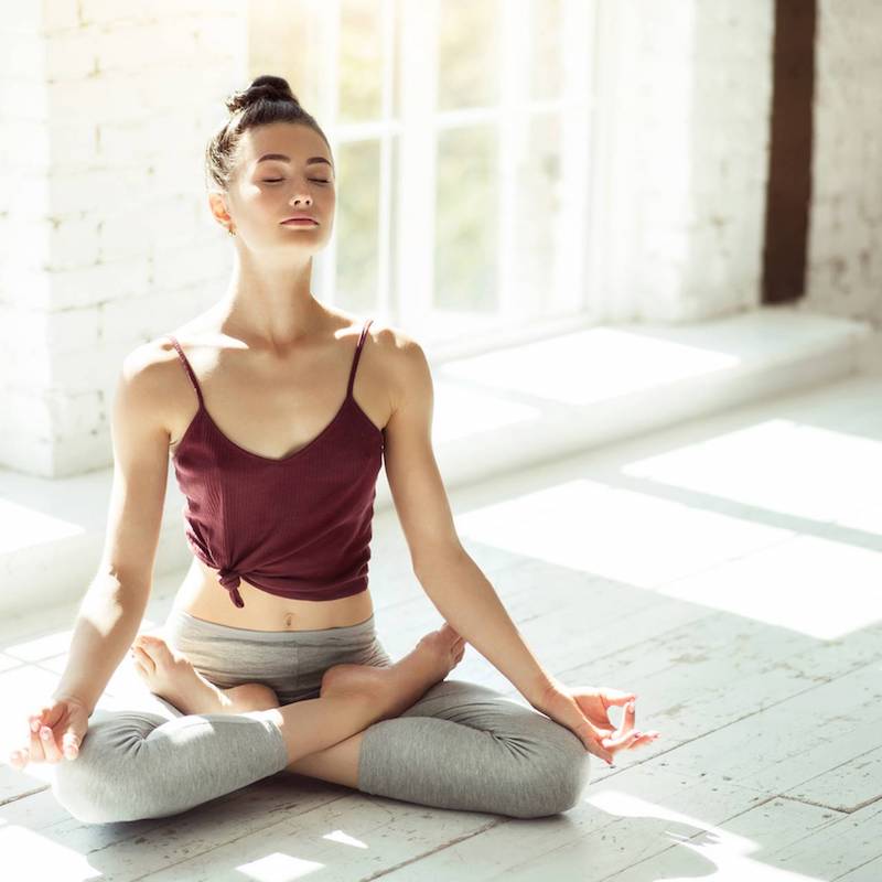 yoga im bett zum einschlafen frau in lotussitz meditieren