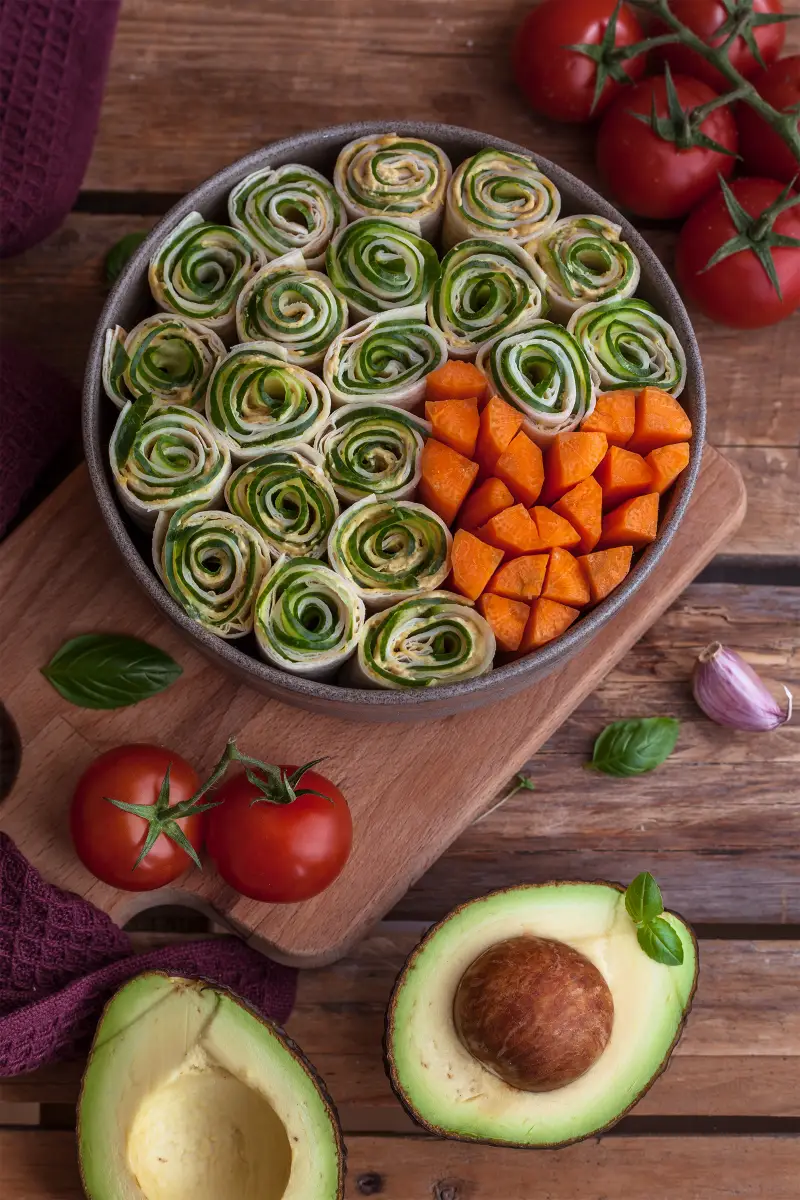 fingerfood vegetarisch kalt grosse platte mit spinat roellchen und frischen karotten streifen avocado