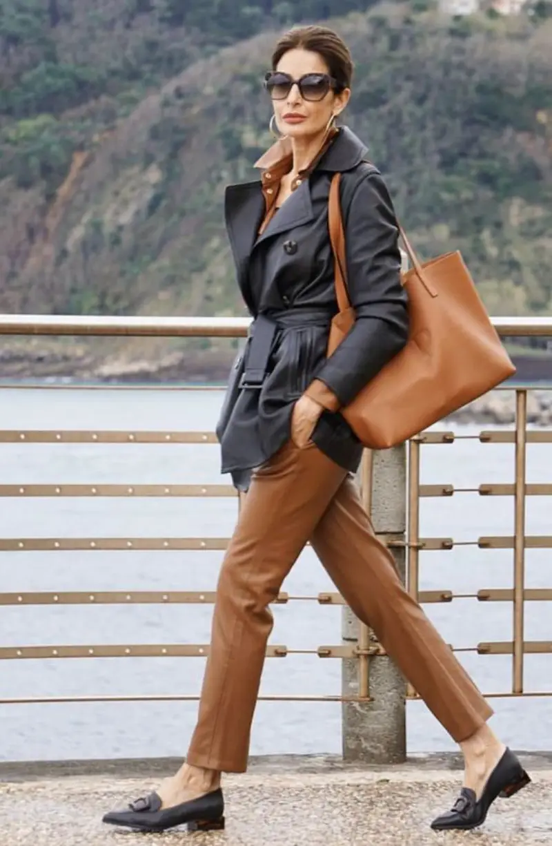 capsule garderobe business capsule garderobe fuer frauen ueber 50 frau mit brauner lederhose schwarzer lederjacke und passenden accessoires