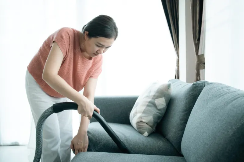 eine frau die das sofa sauber machen wird