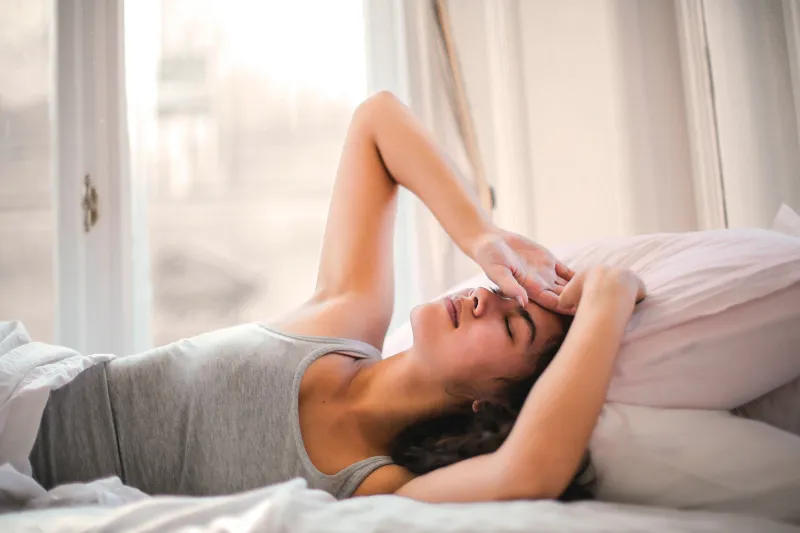 frau im bett wacht auf gesunder schlaf ohne rueckenschmerzen