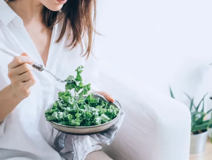 frau isst salat aus gruenkohl aus einer schale