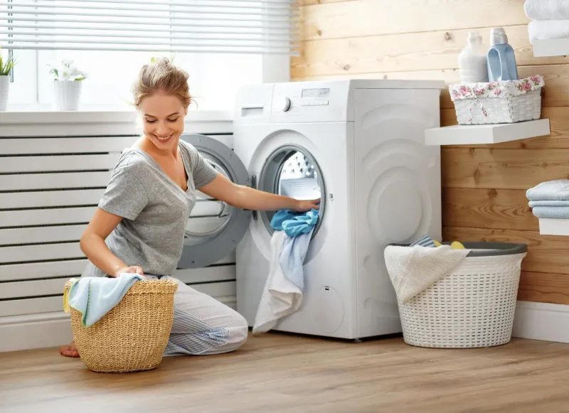 frau waesch handtuecher in der waschmaschine