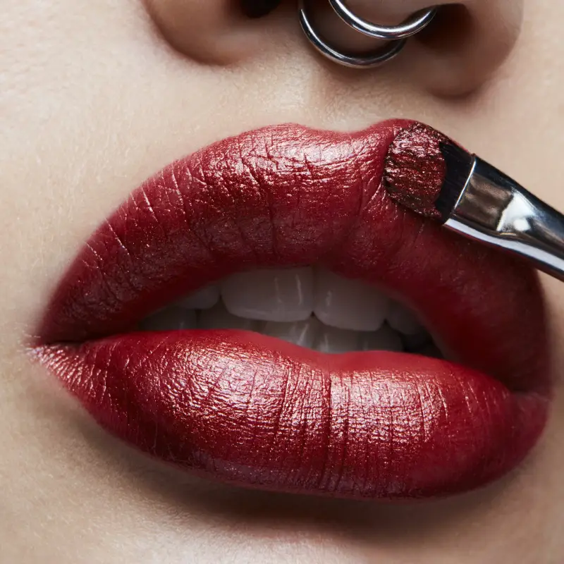 frosted copper lipstick welche farben sind fuer einenfrosted lippen look geeignet frau traegt frosted weinrot lipstick mit buerste