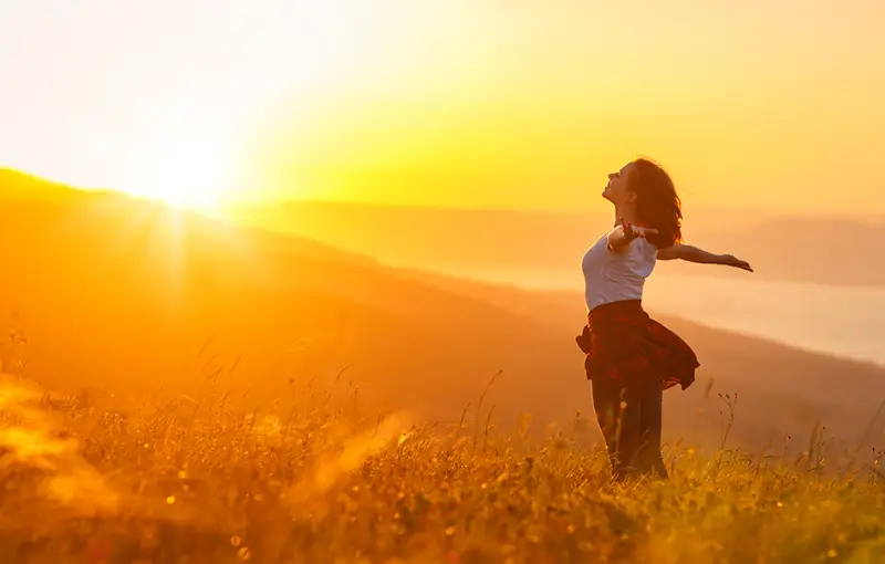 inneres gleichgewicht finden sisu finnland haben froehliche frau im gebirge streckt die haende geniesst den sonnenuntergang