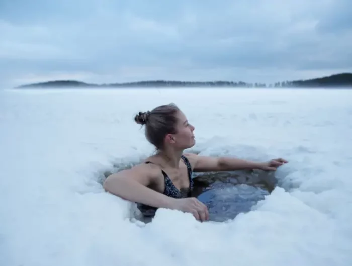 sisu finnland leben eisbad geniessen frau schwimmt im gefrorenem see