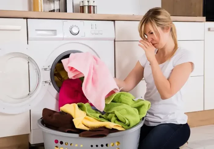 warum stinkt das wasser in der waschmaschine flusensieb waschmaschine wie oft reinigen frau nimmt muffelige kleidung aus der waschmaschine